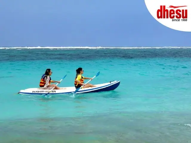 Two people kayaking side by side in clear turquoise water off the Bali coast