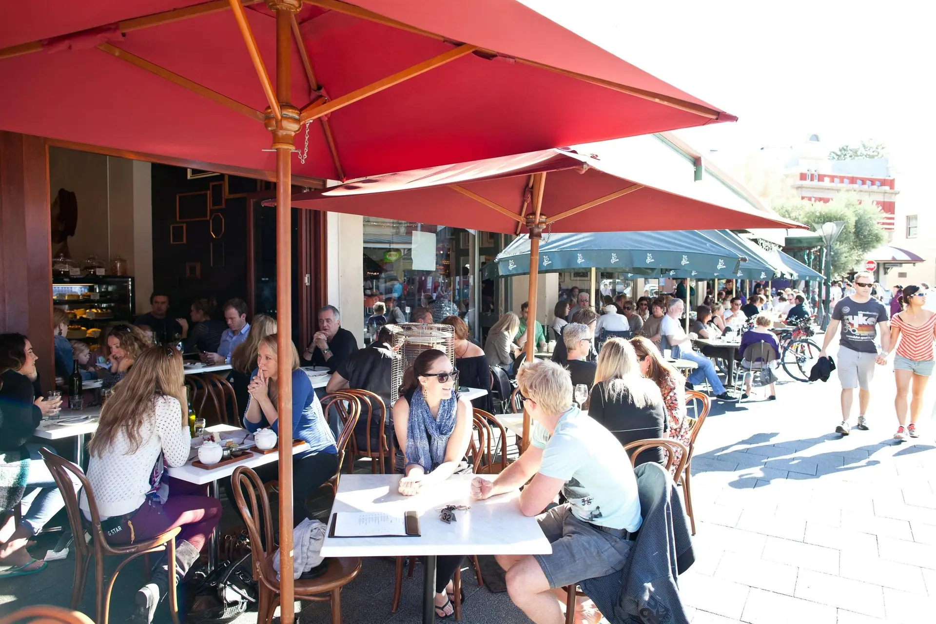 People talking across the tables of a busy café terrace