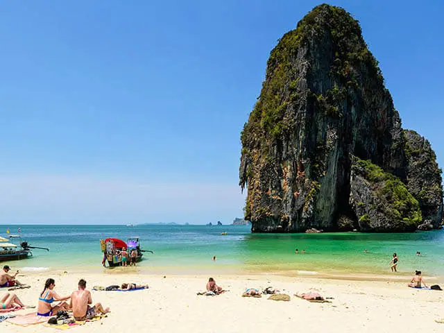 Longtail boat and limestone tower on Phranang Beach, Krabi