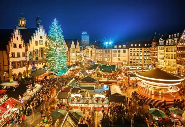 A Christmas market lit up in a European old-town square
