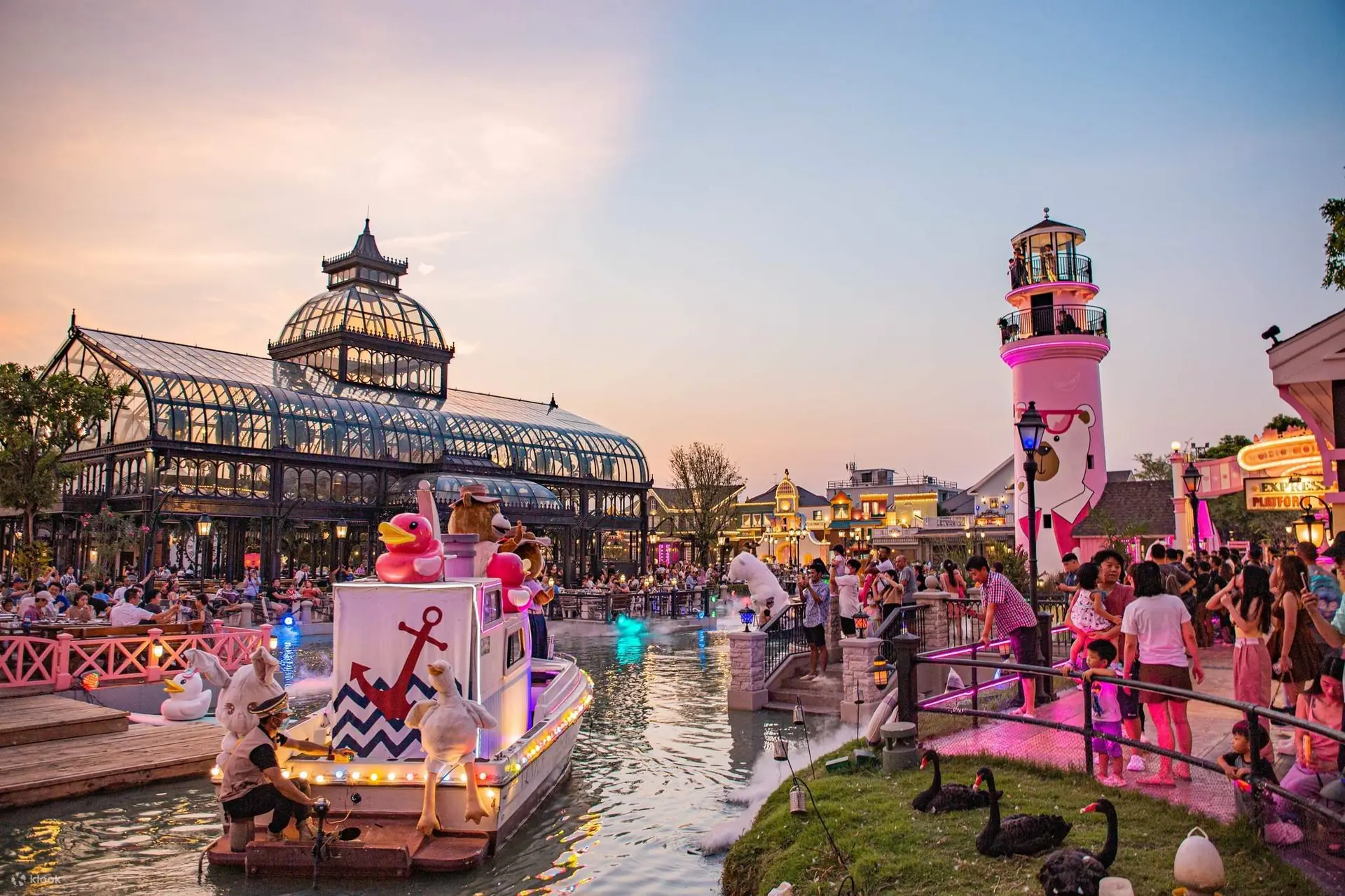 A theme park lit up at dusk during the festive season