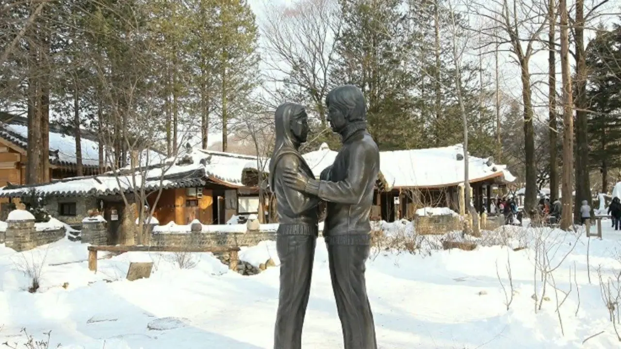 A snow-covered park with bare trees in winter