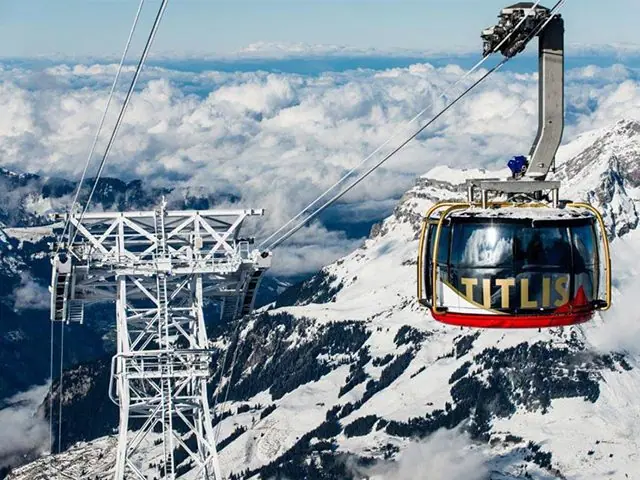 A cable car crossing snow-covered Alpine peaks