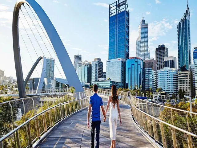 A footbridge over the Dubai Water Canal beneath the city skyline