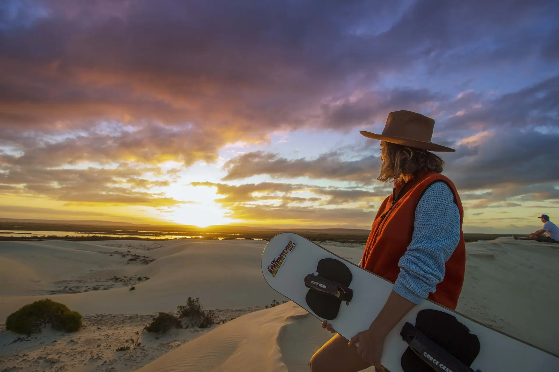 A traveller pausing at a desert overlook at sunset