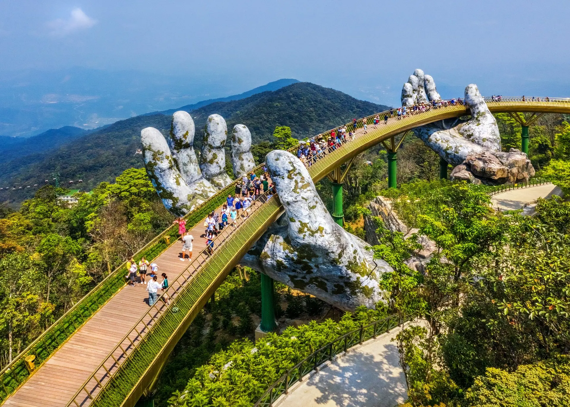 A footbridge curving through forested hills