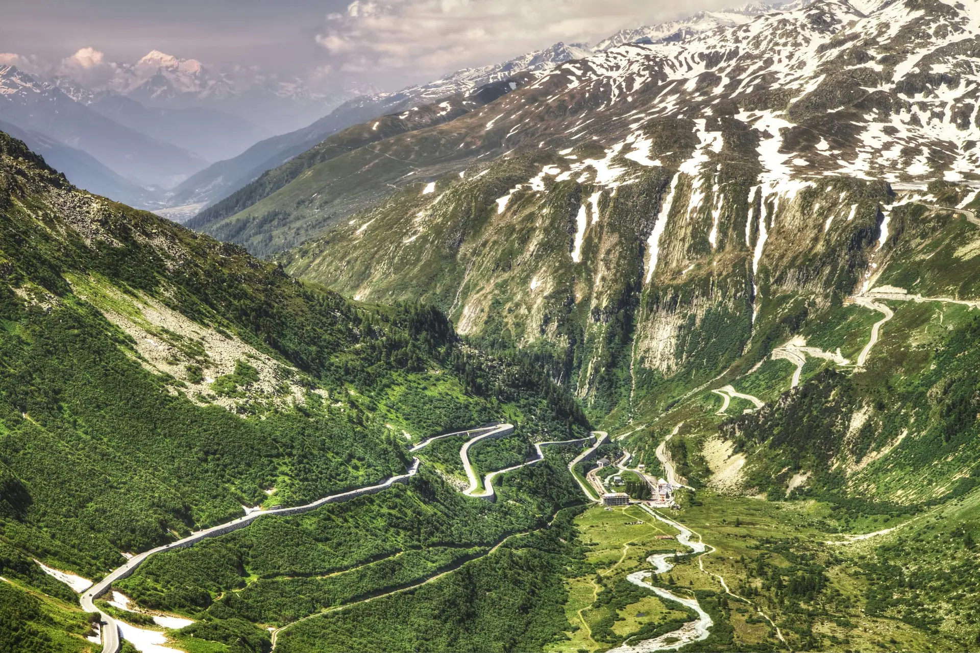 A winding mountain pass road cut into a steep valley